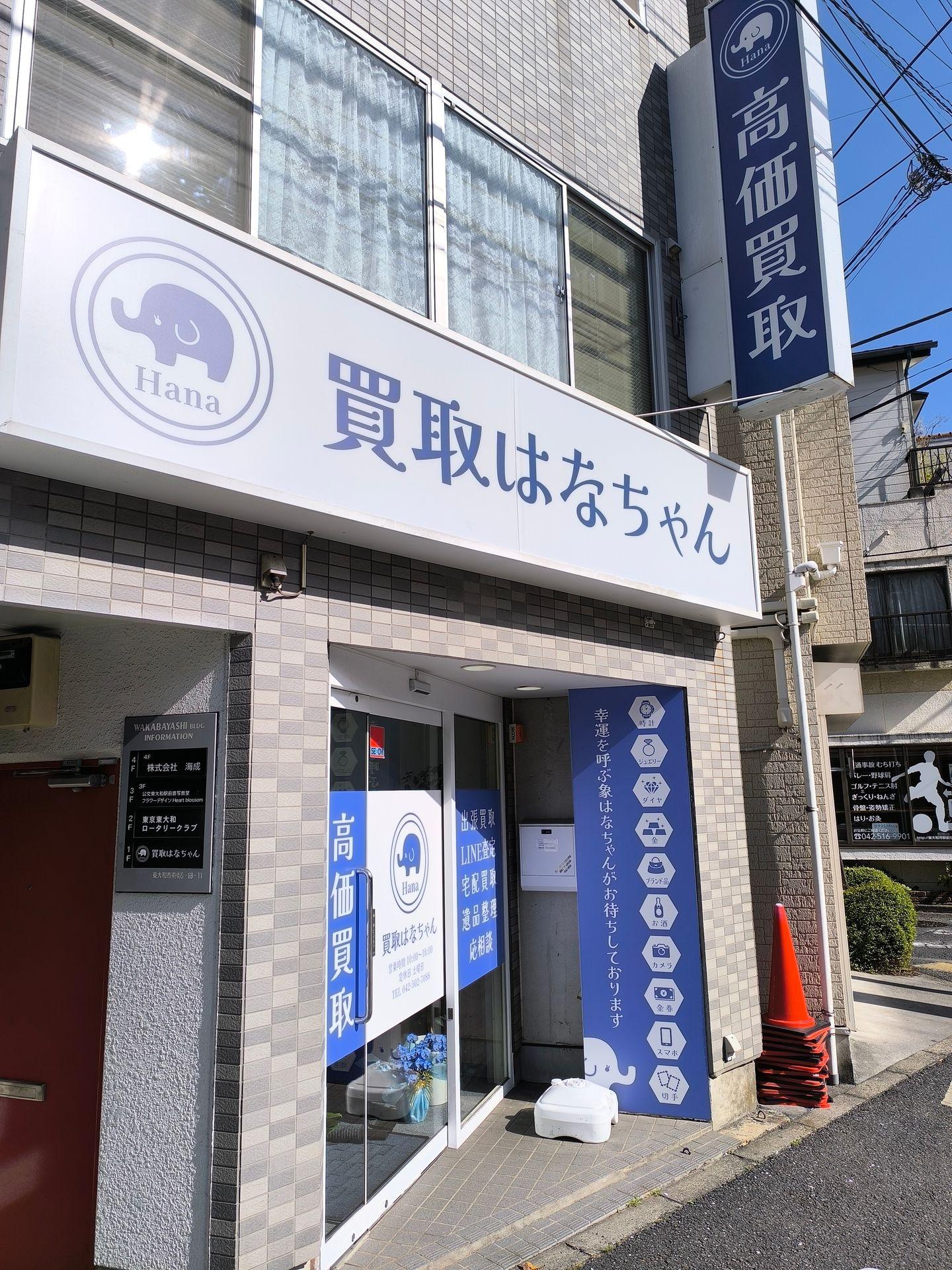 Storefront with blue and white signage, featuring a logo with an elephant and Japanese text.